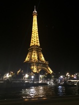 Laivamme tulossa iltavalaistuun Pariisiin, siltojen ali sekä Eiffel-torni.